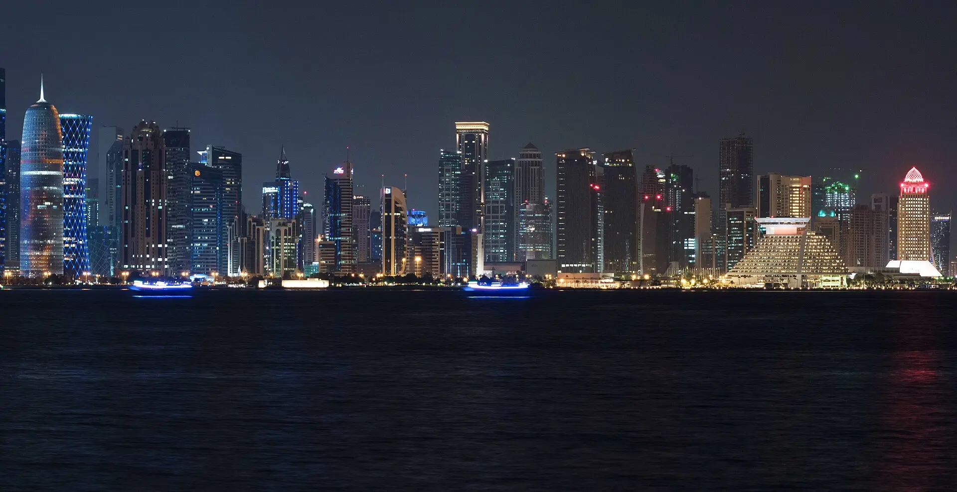 The West Bay towers of Doha lit up at night across the water